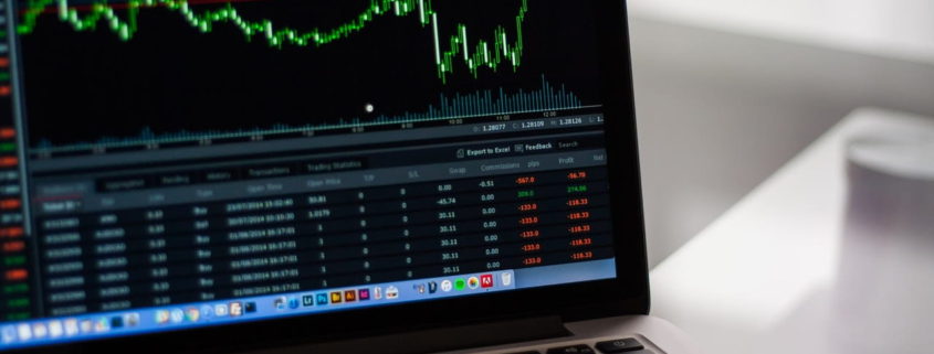 laptop with stock market numbers on screen